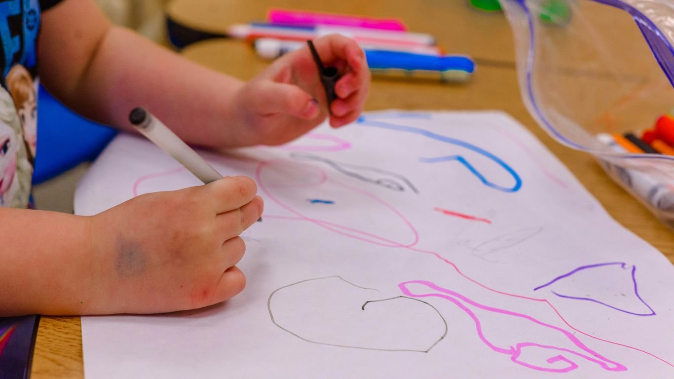 a child is drawing on a piece of paper