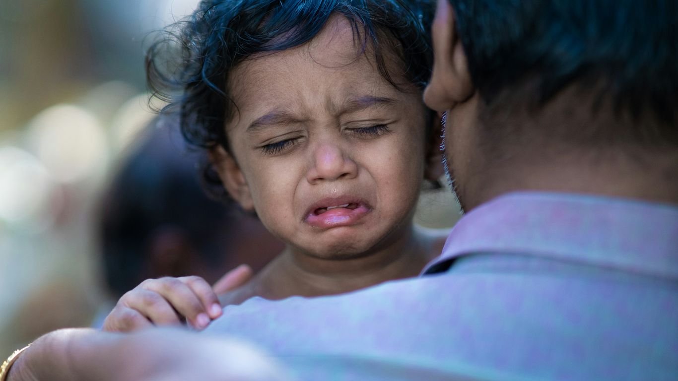 a woman holding a child with a surprised look on her face